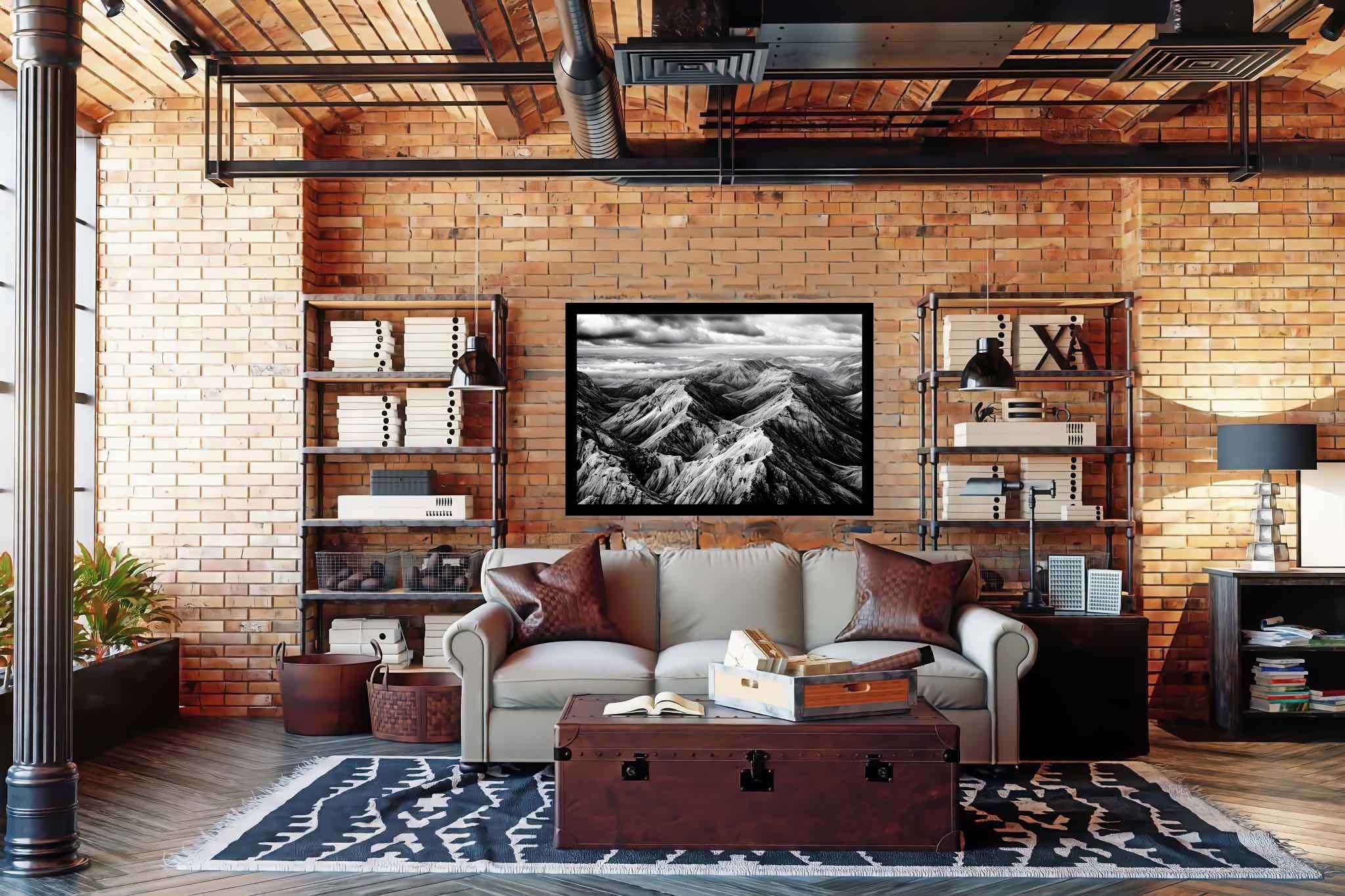 Veiled peaks serenade: Captivating aerial landscape art with stunning aerial imagery, in a room with chic decor, photographic wall art, and trendy home accents. The art can be printed on poster, framed poster, canvas, metal, acrylic or wood, exclusively at WallArtZen. Find this exact print at https://wallartzen.com/waz125